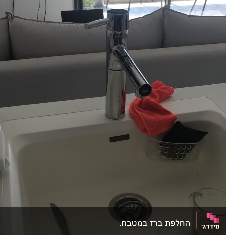 ברז נירוסטה בכיור עם ספוג ומטלית